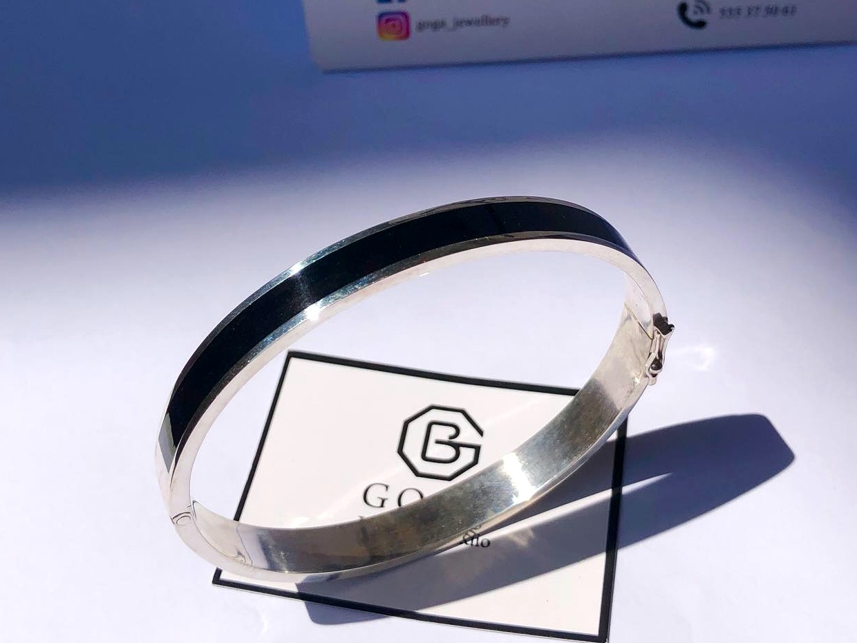Finished silver bangle with dark inlay from prior studio work