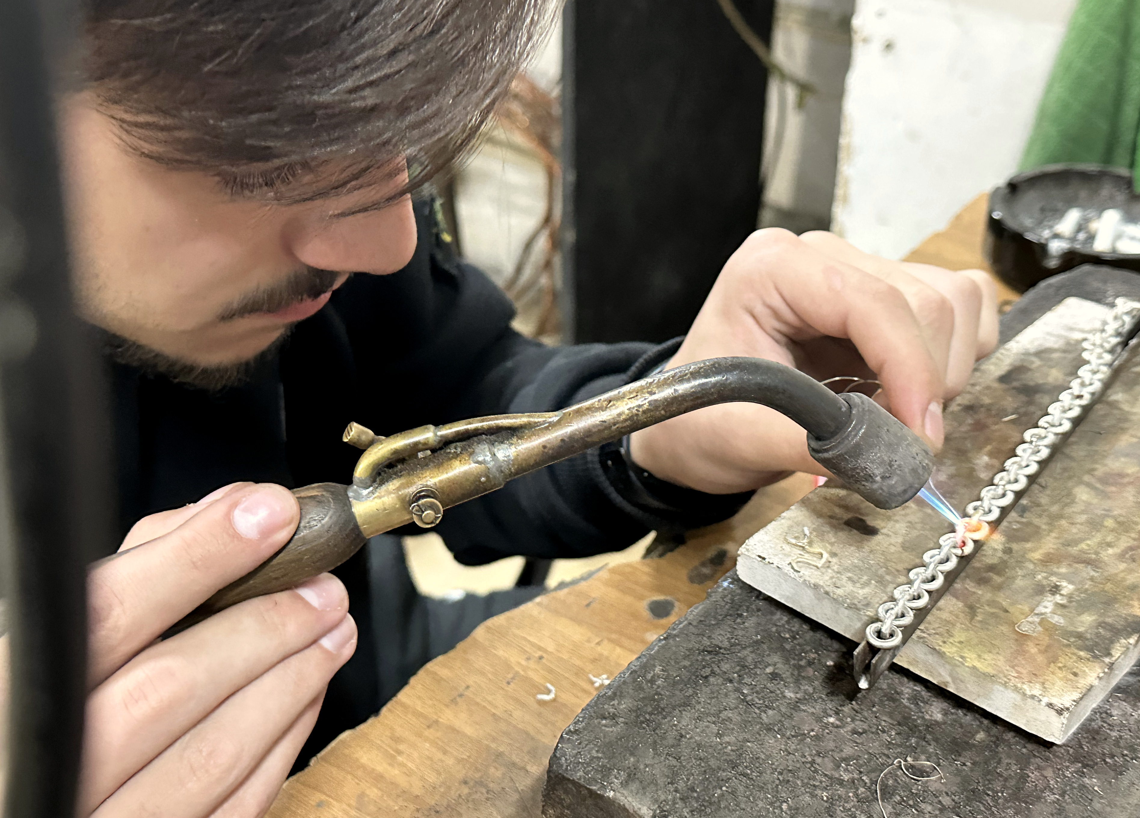 Jeweler working with a torch at a real bench